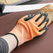 a hand wearing a glove holding a piece of bread