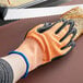 a pair of gloves with orange and white markings