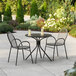 A Lancaster Table & Seating Harbor black table with 2 chairs on a patio.