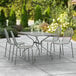 A Lancaster Table & Seating outdoor table and chairs on a patio.