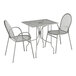 A Lancaster Table & Seating Harbor Gray metal rectangular outdoor table with ornate legs and two arm chairs.