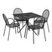 A Lancaster Table & Seating Harbor black metal table with four chairs on an outdoor patio.