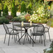 A Lancaster Table & Seating Harbor black table with four chairs on an outdoor patio.