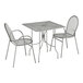 A Lancaster Table & Seating Harbor Gray square outdoor table with ornate legs and two arm chairs on a table with a white background.