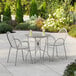 A Lancaster Table & Seating Harbor Gray table and chairs on a patio.