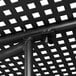 A close up of a black metal Lancaster Table & Seating outdoor table with ornate legs and a grid top.