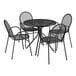 A black metal Lancaster Table & Seating patio table with four chairs on an outdoor patio.