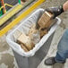 A person holding a Lavex Pro trash bag filled with wood pieces.