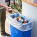 A man putting a bottle into a Lavex Li'l Herc clear trash bag.