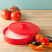 A close up of a red HS Inc. polypropylene tortilla server with a lid.