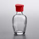 A clear glass Town Round soy sauce bottle with a red lid.