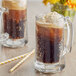 A glass mug of J. Hungerford Smith Root Beer with a straw.