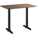 A Lancaster Table & Seating rectangular counter height table with a Yukon Oak finish and black end bases.