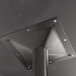 The end of a metal pole with screws and a black square base plate.