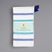 A white dishcloth with a blue stripe pattern and hanging loop.