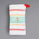 A white dishcloth with red and yellow stripes and a red tag.