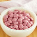 A white bowl filled with Callebaut Ruby chocolate chips.