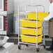 A man in a kitchen assembling a Regency aluminum lug rack with yellow tote boxes on it.