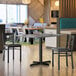 A Lancaster Table & Seating rectangular reversible white and gray slate laminated table top on a table in a restaurant dining area with a cup on it.