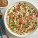 A bowl of salad with meat, rice, and sunflower seeds.