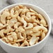 A bowl of raw cashew splits on a table.