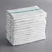 A stack of white towels with green stripes.