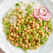 A bowl of rice and peas with a plate of chickpeas on the side.