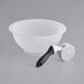 A white bowl with a black handle.
