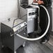 A man in a black shirt using a VITO fryer oil filter machine in a professional kitchen.