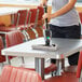 A person using a Unger Stingray microfiber cleaning kit to clean a table in a restaurant.