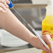 A person using a Quickie straw cleaning brush to clean a straw.
