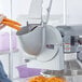 A person using a Shredder and Slicer Attachment to cut carrots.