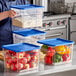 A woman stacking ingredients in Vigor food storage containers.