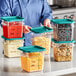 A woman holding a Vigor square clear plastic food storage container with food in it.