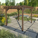 A weathered acorn faux wood pergola in a garden.