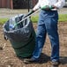 A person using an Unger Nifty Nabber to pick up trash from a trash can.