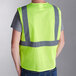 A person wearing a lime Ergodyne GloWear mesh safety vest.