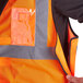 An orange Ergodyne high visibility vest with reflective tape and black accents.