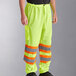 A person wearing Ergodyne GloWear 8911 lime yellow and orange reflective safety pants.