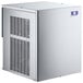 A white Manitowoc air cooled nugget ice machine with a white and silver label.
