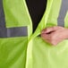 A person pulling a yellow Ergodyne safety vest.