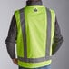 A man wearing an Ergodyne lime green surveyor vest with reflective stripes.