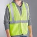 A man wearing an Ergodyne lime high visibility mesh vest.