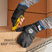 A person wearing Ergodyne ProFlex thermal fingerless work gloves cutting a box.