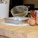 An 8" square foil cake pan on a counter.