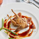 A plate of food with a fork and knife next to a Manchester Farms semi boneless quail.