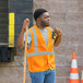 A man in an orange Ergodyne GloWear reflective vest holding a tool.