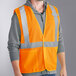 A man wearing an orange Ergodyne high visibility mesh vest with reflective stripes.
