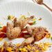 A plate of food with Manchester Farms semi boneless quail and a fork.