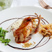 A white plate with a whole quail, green beans, and a fork.